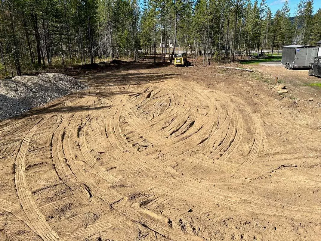 Large lot of smoothly graded dirt with swirling track marks, ready for construction