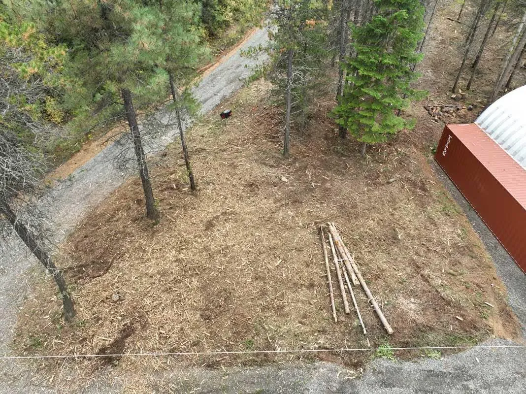 Aerial view of a hillside cleared of brush beside a gravel road